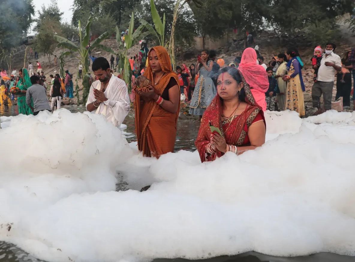 Feligreses en India desafían prohibición y se bañan en río Yamuna cubierto de espuma tóxica